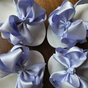 Large blue coloured bows on high wedge heel flip flops