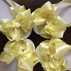 Large lemon coloured bows on high wedge heel flip flops